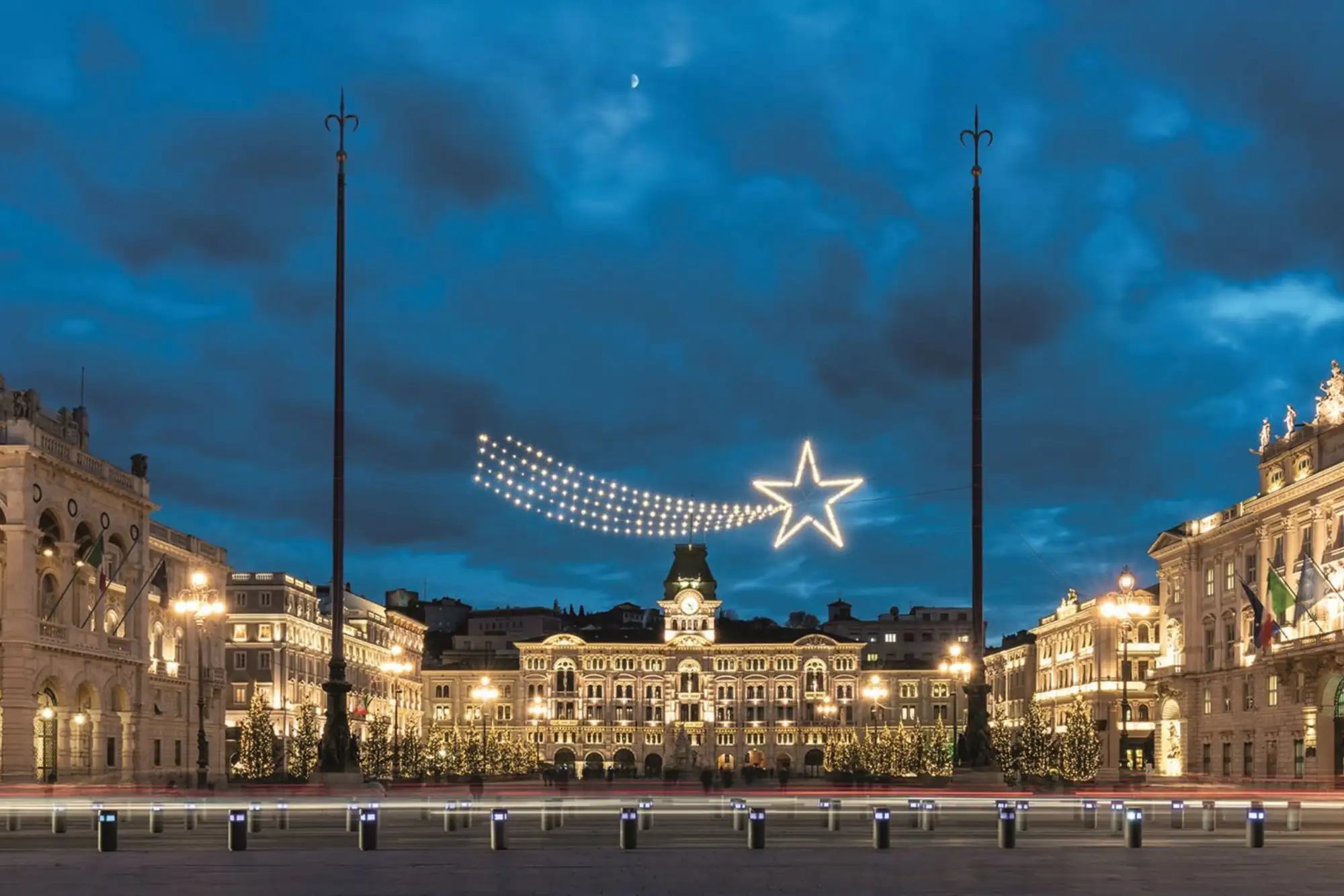 Piazza Unità d’Italia a Trieste illuminata per Natale con una grande stella cometa luminosa sopra il Palazzo del Municipio.